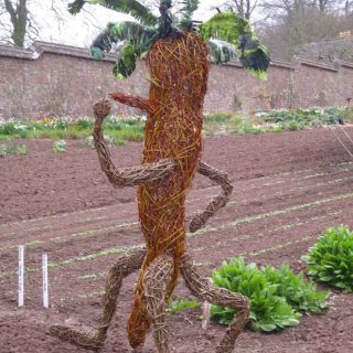 Willow sculpture of giant walking carrot man