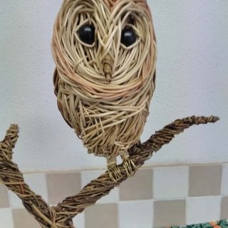 Barn owl sitting. Willow sculpture.