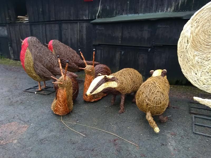 willow sculptures of giant robin,badger and snail.